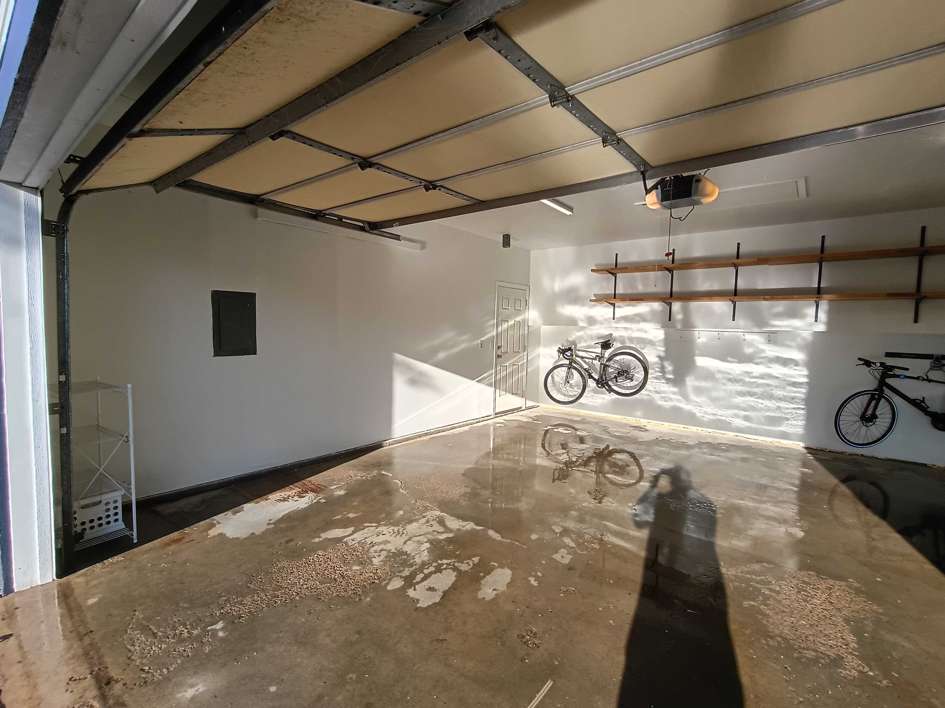Cottage Grove garage after interior painting, white walls and natural wood shelves