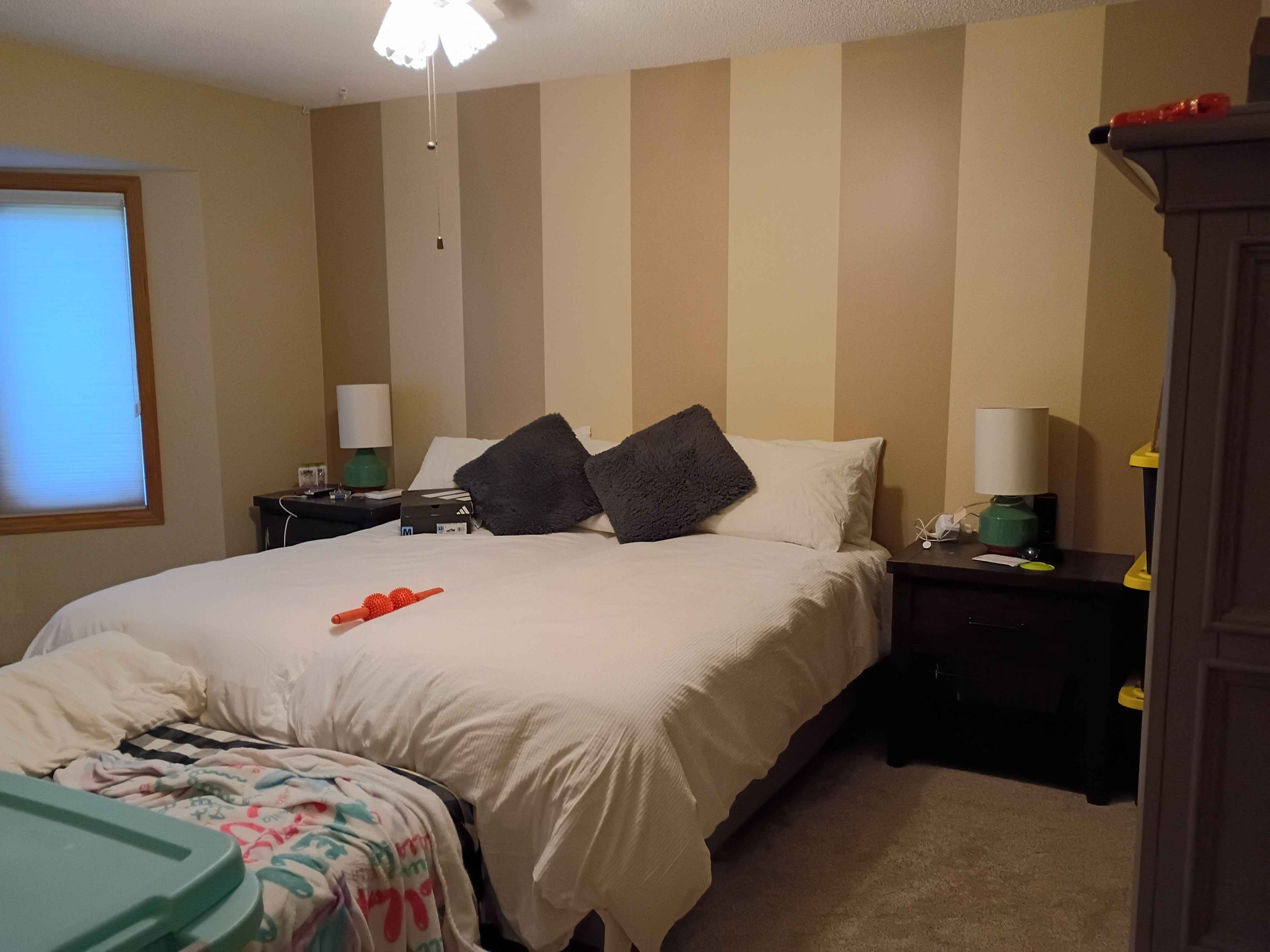 Ham Lake striped bedroom after painting, bed back in the room